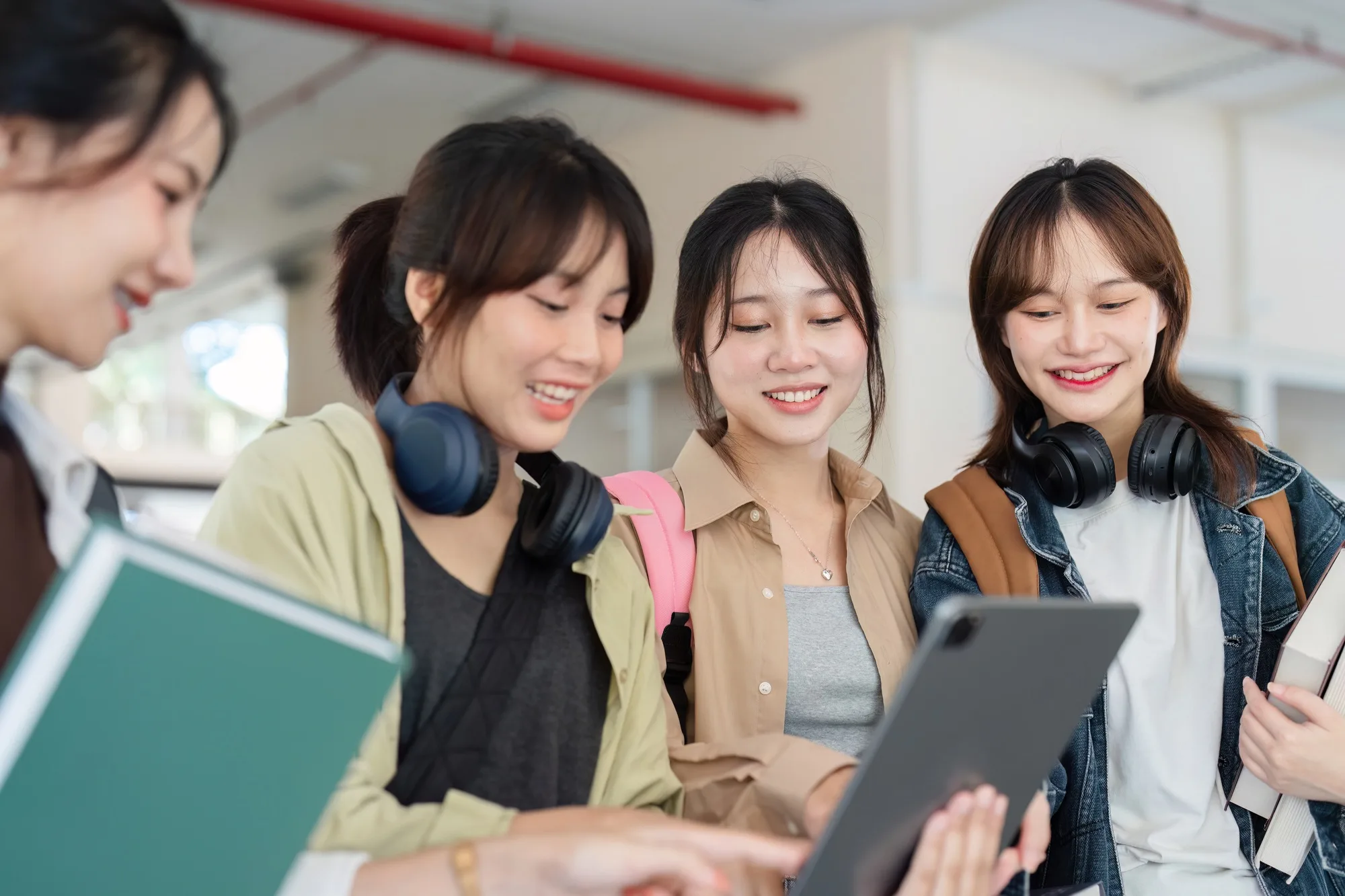 university students using a digital tablet while walking to next class