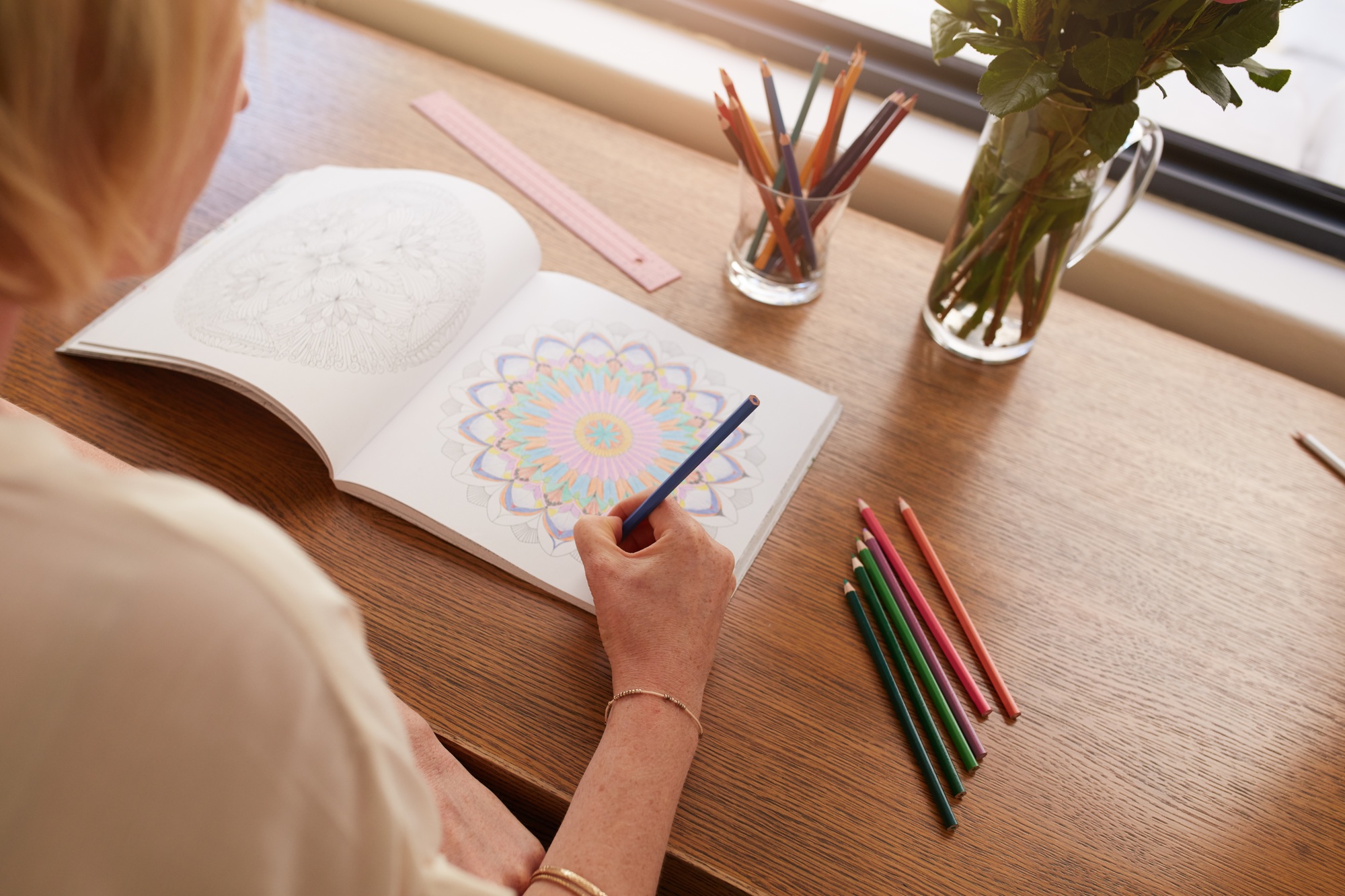 Woman drawing in colouring book for adults
