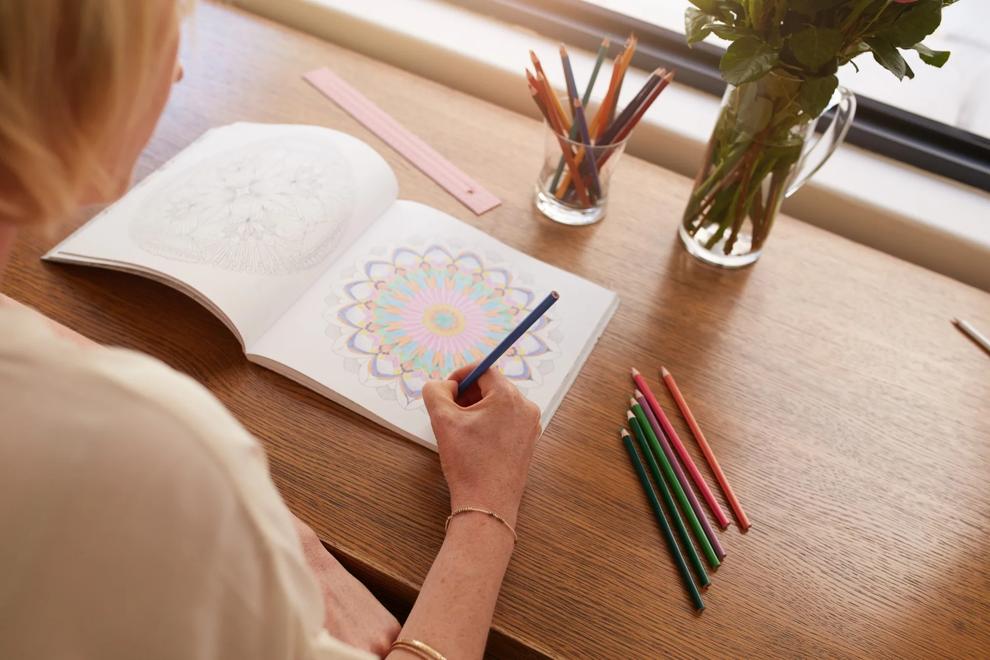 Woman drawing in colouring book for adults